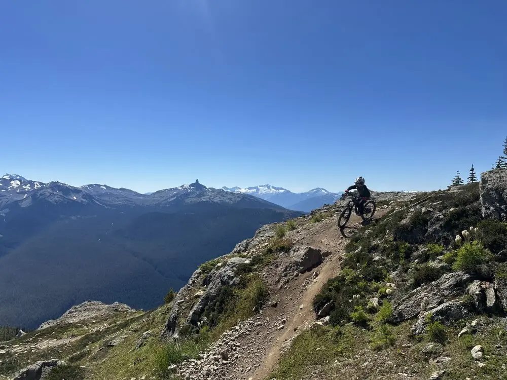 A mountain biker descending a high alpine ridge trail at Whistler